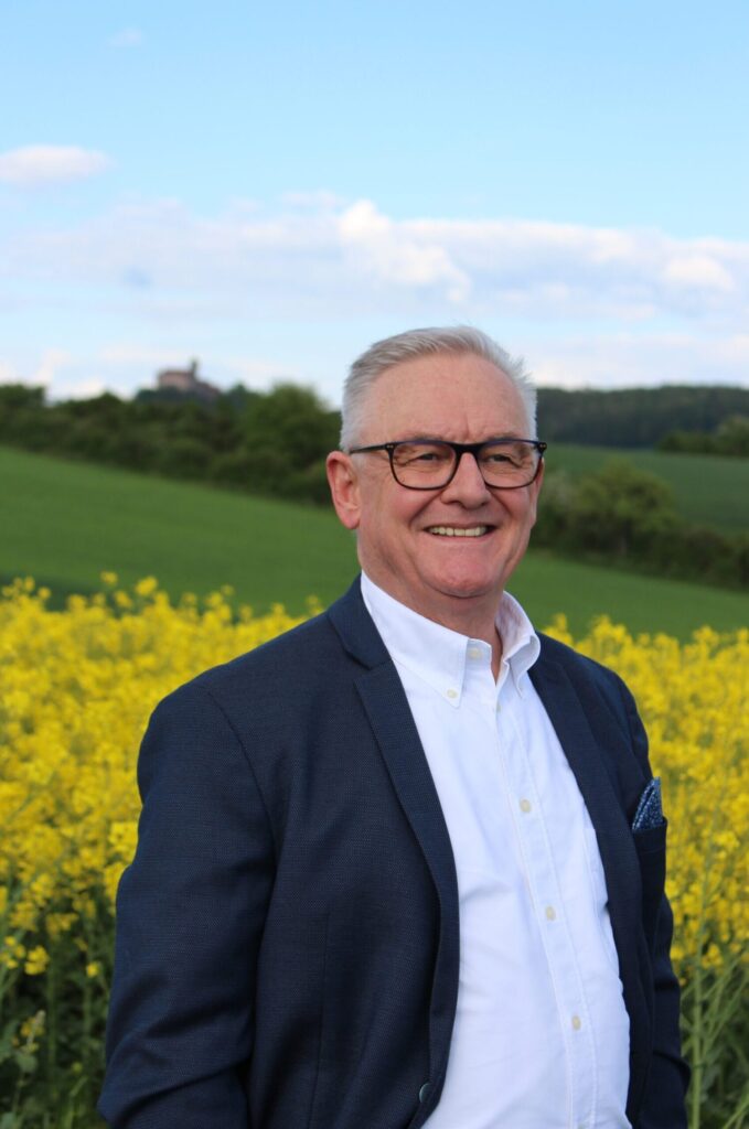 Jürgen Scharfenorth vor Rapsfeld, Ronneburg im Hintergrund